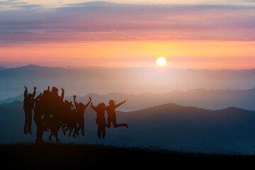 Silhouette of Business teamwork hands up and jump to the beautiful golden sky,The concept of business sucess,victory,achieve target goal,busness growth.