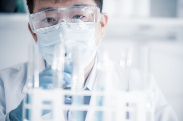 Asian male scientist working in a laboratory. Vaccine development concept.