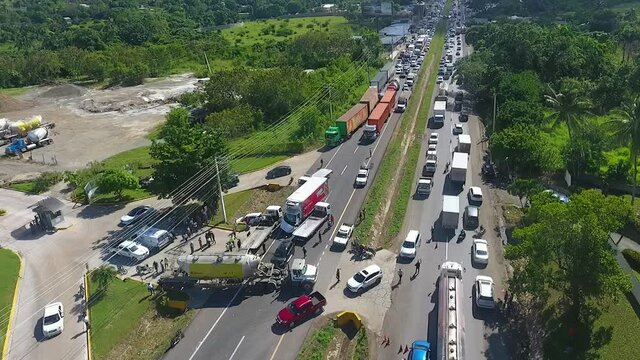 Aerial view overlooking a queue of cars, traffic Jam due to a truck accident, passenger vehicle crushed under a truck, in San Diego, California, USA, America - tracking, drone shot