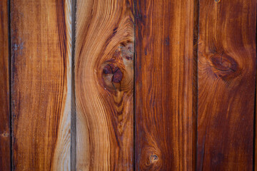 Wooden background, close-up. Brown vertical boards. Facing the exterior walls of the house. Ramshackle wall with peeling paint.