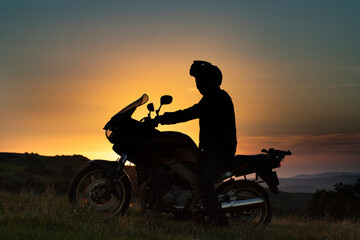 Plakat Man on his motorbike riding into sunset