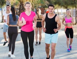 People leading healthy lifestyle, jogging during outdoor workout on city seafront