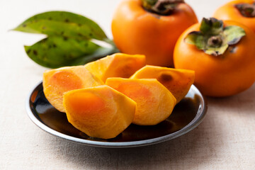 Fototapeta na wymiar Cut Japanese persimmons on a plate