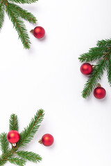 Minimal christmas composition. Fir tree branches with golden christmas balls on white background. Vertical