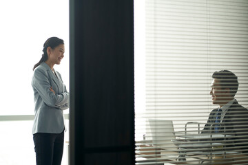 asian businessman and businesswoman chatting in office