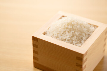 Rice in a Japanese Masu in a wooden background