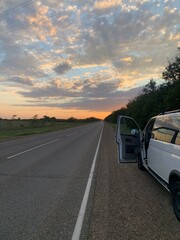 car on the road in sunset