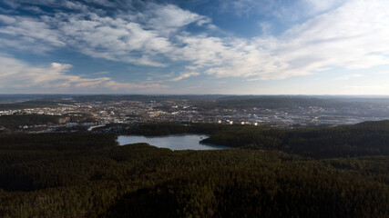 Aerial scene of forest and lake with the suburbs of Oslo city in the background