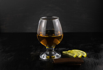 A glass of cognac chocolate and lemon wedges