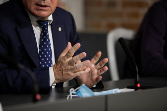 businessman sitting at a table with a microphone, speaking to journalists, conference, business training