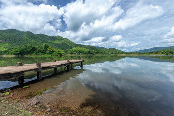 Fototapeta premium view of the wooden pier in the lake with mountain scenery background. in the early morning.