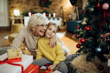 Joyful senior woman and her granddaughter enjoying on Christmas at home.