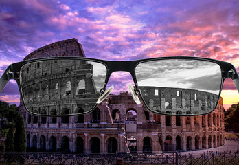 Looking through glasses to bleach Colosseum in Rome at sunset against purple cloudy sky, Italy....