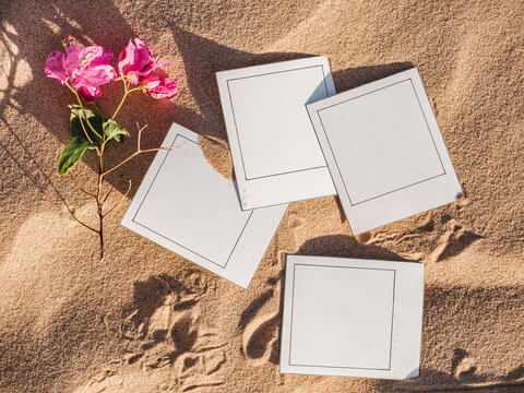 Beautiful photos lying on sand background. View from above, close-up. Concept of leisure and travel