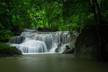 Fototapeta na wymiar A beautiful waterfall deep in the tropical forest, steep mountain adventure in the rainforest.