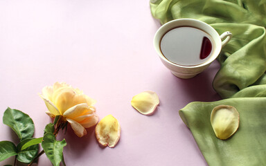 A Cup of tea with a delicate rose on a light background, side view, space for text