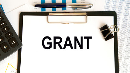 GRANT text, next calculator, pen, reports. A business concept.