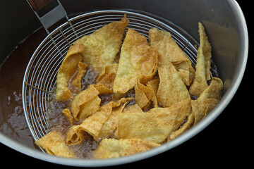 Deep fried wontons dumplings in oil.