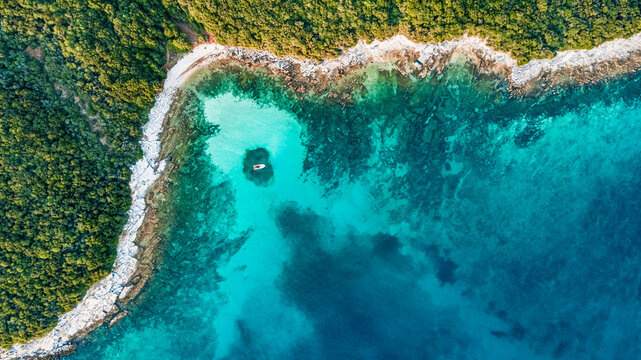 Drone view of the seashore with a boat at Cisterna beach Rovinj Croatia