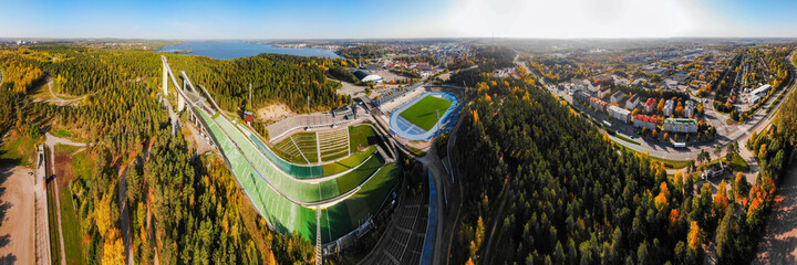 Aerial panoramic view of Lahti sports centre with three ski jump towers.