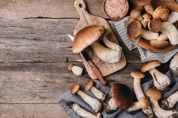 Autumn harvest concept. Fresh picked Porcini mushrooms in basket. Fresh forest boletus mushrooms on wooden background. Top view. Copy space.