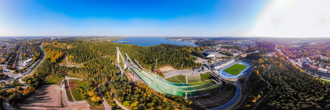 Aerial panoramic view of Lahti sports centre with three ski jump towers.