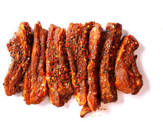 Raw uncooked fresh pork belly slices on white background. Meat marinated with traditional Korean marinade with oil and herbs
