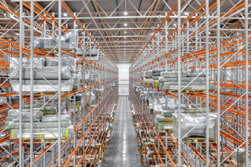 Large warehouse. Tall and long metal racks filled with various boxes, containers and drawers