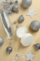 Fototapeta na wymiar Jar of cosmetics cream and New year accessories on beige background