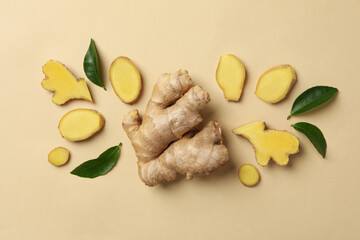 Fresh ginger and leaves on beige background