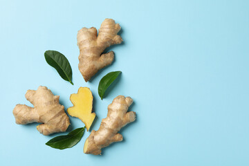 Fresh ginger and leaves on blue background