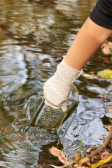 A scientist collects river water in a glass beaker.