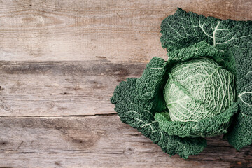 Raw green cabbage texture. Organic savoy cabbage on wooden background. Top view. Copy space. Vegan...