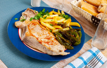 Fried Iberian pig served with potatoes, parsley and stewed pepper