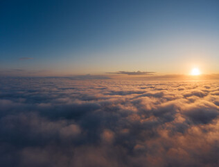 Fototapeta na wymiar Beautiful sunrais cloudy sky from aerial view. Airplane view above clouds