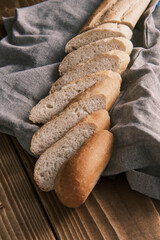 Close up fresh sliced French baguette on a linen cloth on a wooden table