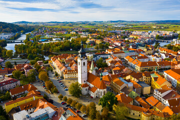 Fototapeta na wymiar Scenic view from drone of historic center of small Czech town of Pisek on banks of Otava river with Church of Nativity of Blessed Virgin Mary on autumn day..
