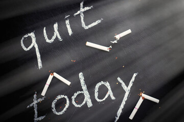 Stop smoking today concept. Broken cigarettes and inscription- quit today.