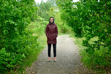 A woman walks in a green park.