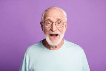 Portrait of amazed old man wear casual t-shirt spectacles open mouth isolated on purple color background