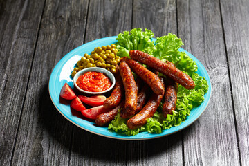 English meal: pork sausages with peas and lettuce