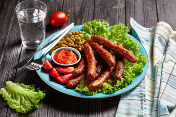 English meal: pork sausages with peas and lettuce