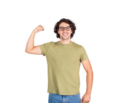 Joyful young man flexing one hand biceps, imagine superpower. Nerd guy wears eyeglasses shows his muscle strength, smiling positive to camera. Personal development, power and motivation concept.