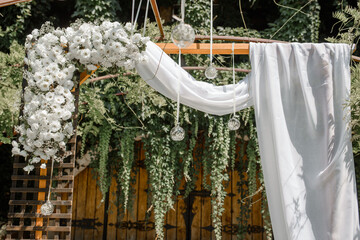 Wedding arch decorated with white flowers on a wedding ceremony outdoor
