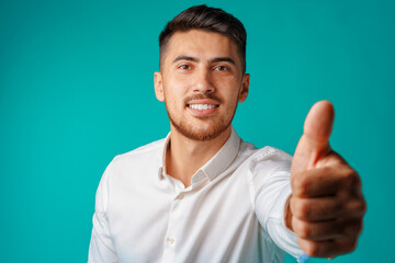 Positive handsome hispanic businessman showing thumb up gesture