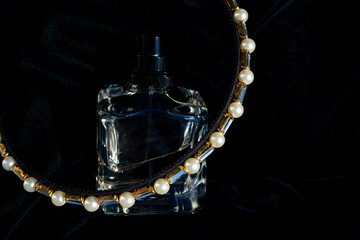 Composition with perfume and accessories for head on black background