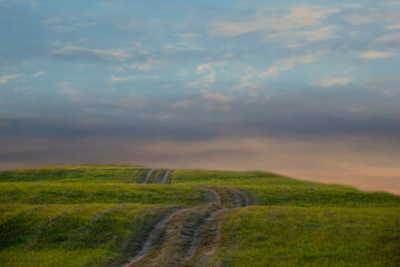 Obraz premium The photo shows a road in the mountains at sunset.