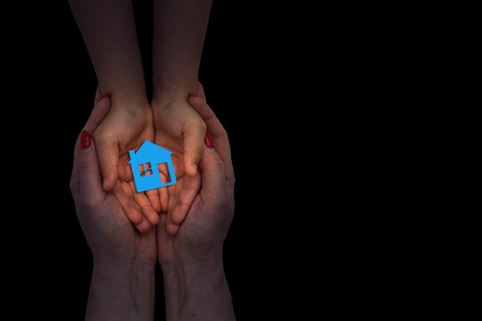 people, charity, family and home concept - close up of woman and girl holding paper house cutout in cupped hands