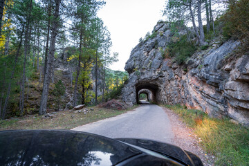 Car entering tunnel dug into the rocks