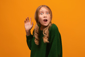 Image of shocked blonde teen expressing surprise on camera. Studio shot, yellow background. Human emotions concept